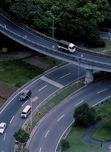 Bus, camion et voitures circulant sur un échangeur urbain à plusieurs niveaux