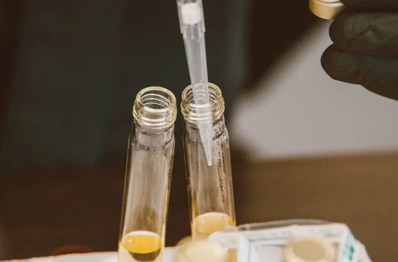 Pipette au-dessus de tubes de prélèvement dans un portoir de laboratoire